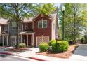 Two-story townhome with brick facade, an attached garage, and a well-maintained lawn at 1396 Dolcetto Nw Trce # 12, Kennesaw, GA 30152
