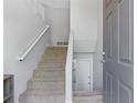 Bright entryway with a carpeted staircase, white railing, and a door to a lower level at 257 Browning Cir, Acworth, GA 30101