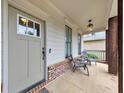 Inviting front porch with seating, brick accents, and a decorative overhead light fixture at 1026 Towne Mill Xing, Canton, GA 30114