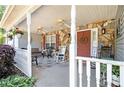 Inviting front porch with stone accents, ceiling fans, swing, rocking chairs and a charming welcome sign at 65 Macadamia Ct, Covington, GA 30016