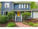 Inviting front porch with a bright yellow door, gray steps, and manicured landscaping at 2317 Danielle Ct, Marietta, GA 30062