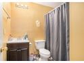Bathroom featuring a toilet, vanity with dark cabinets, and shower with gray curtain at 2326 Nicole Dr, Hampton, GA 30228