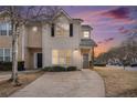 Charming townhouse with a well-maintained lawn and private driveway at sunset at 2326 Nicole Dr, Hampton, GA 30228