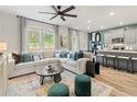 Open-concept living room with natural light, modern furnishings, and eat-in kitchen at 400 Brooch Way, Stockbridge, GA 30281