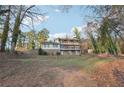 View of multi-story home surrounded by mature trees, adding privacy and natural beauty to the property at 2667 Fieldstone Se Dr, Conyers, GA 30013