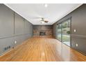 Living room featuring a brick fireplace, hardwood floors, and sliding glass doors to let in plenty of light at 2667 Fieldstone Se Dr, Conyers, GA 30013
