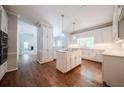 Bright kitchen featuring white cabinetry, hardwood floors, a center island, and stainless steel appliances at 4320 Royal Mustang Way, Snellville, GA 30039