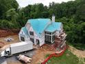 An exterior view of a house under construction with scaffolding, showcasing its design and structure at 469 Emily Reed Ln, Atlanta, GA 30342