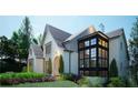 Landscaped painted brick home featuring an arched entryway and a black framed modern window feature at 469 Emily Reed Ln, Atlanta, GA 30342