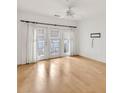 Bedroom featuring light-colored hardwood floors, double doors with blinds, and large windows offering bright, natural lighting at 799 Hammond Dr # 314, Atlanta, GA 30328