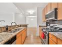 Kitchen showcasing stainless steel appliances, granite countertops, and cabinetry against the backdrop of natural wood flooring at 799 Hammond Dr # 314, Atlanta, GA 30328