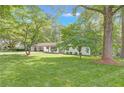 Welcoming home with a large lawn, mature trees, and a convenient two-car carport at 1391 Arden Sw Dr, Marietta, GA 30008