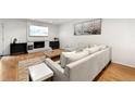 Bright living room with hardwood floors, white brick fireplace, and neutral furniture at 113 Courtyard Ter, Roswell, GA 30075