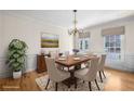 Elegant dining room with wood table, chandelier, wainscoting and large window at 1584 Fernstone Nw Cir, Acworth, GA 30101