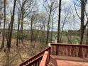 Wooden deck with railings overlooking a serene backyard surrounded by tall trees, providing a sense of privacy at 602 Springharbor Dr, Woodstock, GA 30188