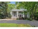 Elegant two-story white home featuring a meticulously maintained lawn and a circular driveway at 1011 W Paces Ferry Nw Rd, Atlanta, GA 30327