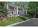 Beautiful two-story home with grand entrance, landscaped lawn, and mature trees at 1011 W Paces Ferry Nw Rd, Atlanta, GA 30327