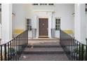 Close-up of front door with wrought iron railings, classic columns, and charming yellow benches at 1011 W Paces Ferry Nw Rd, Atlanta, GA 30327