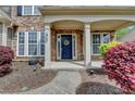 Inviting front entrance with stone accents, white columns, and a beautifully landscaped yard at 4280 Azurite St, Cumming, GA 30040