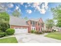 Charming brick home with a well-manicured lawn and an attached two-car garage at 745 Amberton Close, Suwanee, GA 30024
