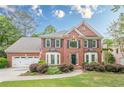 Attractive brick house with tidy landscaping, and a well-kept lawn at 745 Amberton Close, Suwanee, GA 30024