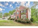 Traditional brick home featuring manicured landscaping, lush green grass, and classic architectural details at 745 Amberton Close, Suwanee, GA 30024
