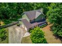 Aerial view of a two-story home, showcasing its manicured lawn, two-car garage, mature trees and fenced backyard at 3987 Ivory Gables Pl, Buford, GA 30519