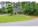 Inviting two-story home with lush green lawn and mature trees enhancing its curb appeal in a tranquil setting at 3987 Ivory Gables Pl, Buford, GA 30519