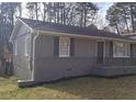Cozy home featuring a charming front porch, gray wood siding, and black window shutters at 1677 Wayland Ne Cir, Brookhaven, GA 30319