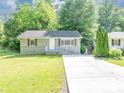 Charming home featuring a well-maintained lawn, gray painted brick foundation and concrete driveway at 1677 Wayland Ne Cir, Brookhaven, GA 30319