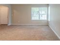 Spacious living room featuring a large window, plush carpeting, and ample space for furniture arrangement at 3897 Mcgill Dr, Decatur, GA 30034
