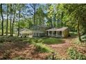 View of the two-story house in its large lot with mature trees surrounding the residence at 4628 Mountain Creek Ne Dr, Roswell, GA 30075