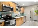 Well-lit kitchen featuring modern appliances, light wood cabinets, subway tile backsplash, and easy access to the laundry at 67 Lannon Ne Ave, Atlanta, GA 30317