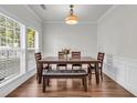 Bright dining room with hardwood floors, a modern light fixture, and large windows at 335 Pintail Ct, Suwanee, GA 30024