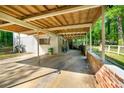 Carport featuring a concrete floor, brick wall, and wood ceiling at 4882 Rock Haven Sw Dr, Lilburn, GA 30047