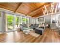 Bright living room featuring hardwood floors, large windows with backyard views, and stylish, comfortable furniture at 4882 Rock Haven Sw Dr, Lilburn, GA 30047