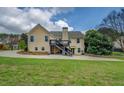 Exterior of home from the backyard, showcasing the deck and landscaped lawn at 116 Laurel Ln, Social Circle, GA 30025