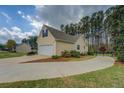 Side view of a well-maintained home featuring an attached two-car garage and long driveway at 116 Laurel Ln, Social Circle, GA 30025