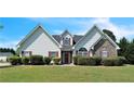 Inviting home exterior featuring stone accents, red shutters and a well-manicured lawn at 152 Ridge Xing, Temple, GA 30179