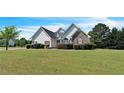 Attractive home exterior with a well-maintained lawn, mature trees, and stone detailing at 152 Ridge Xing, Temple, GA 30179