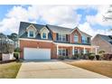 Traditional two-story brick home featuring a covered front porch and attached two-car garage at 362 Interlake Pass, Mcdonough, GA 30252