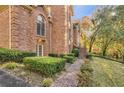 Side view of a two story brick home with a manicured lawn and garden area and a brick sidewalk at 415 Collegiate Dr, Powder Springs, GA 30127