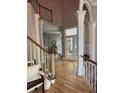 Light-filled foyer featuring hardwood floors, white pillars, high ceilings, and view into the living space at 415 Collegiate Dr, Powder Springs, GA 30127