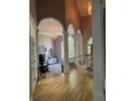 Spacious foyer with arched openings, wood floors, and view into the living space with fireplace and large windows at 415 Collegiate Dr, Powder Springs, GA 30127