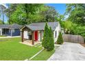 Exterior view of a home with a well-maintained lawn, driveway, and welcoming red front door at 360 New Jersey Nw Ave, Atlanta, GA 30314
