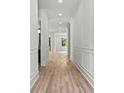Long hallway with light wood floors, white wainscoting and molding, and recessed lighting at 267 Green Hill Rd, Sandy Springs, GA 30042