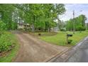 Long driveway leading up to a house on a beautiful lot with green lawns and mature trees at 408 Walnut Dr, Woodstock, GA 30189