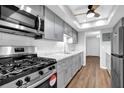 Modern kitchen featuring stainless steel appliances, gray cabinets, sleek countertops, and ample natural light from a ceiling fan at 6851 Roswell Rd # C7, Atlanta, GA 30328