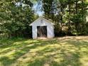 A well-maintained shed nestled in a green backyard, offering extra storage with double doors, and ventilation at 2682 Pineland Ave, Atlanta, GA 30340