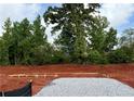 Construction site shows a home's foundation on a wooded lot with trees in the background at 496 Charleston Pl, Villa Rica, GA 30180